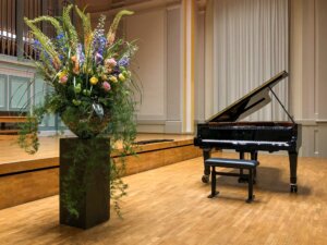 Grand piano in a concert hall with flower decoration