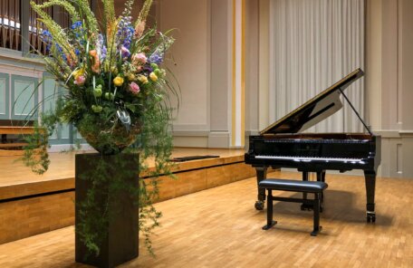 Grand piano in a concert hall with flower decoration